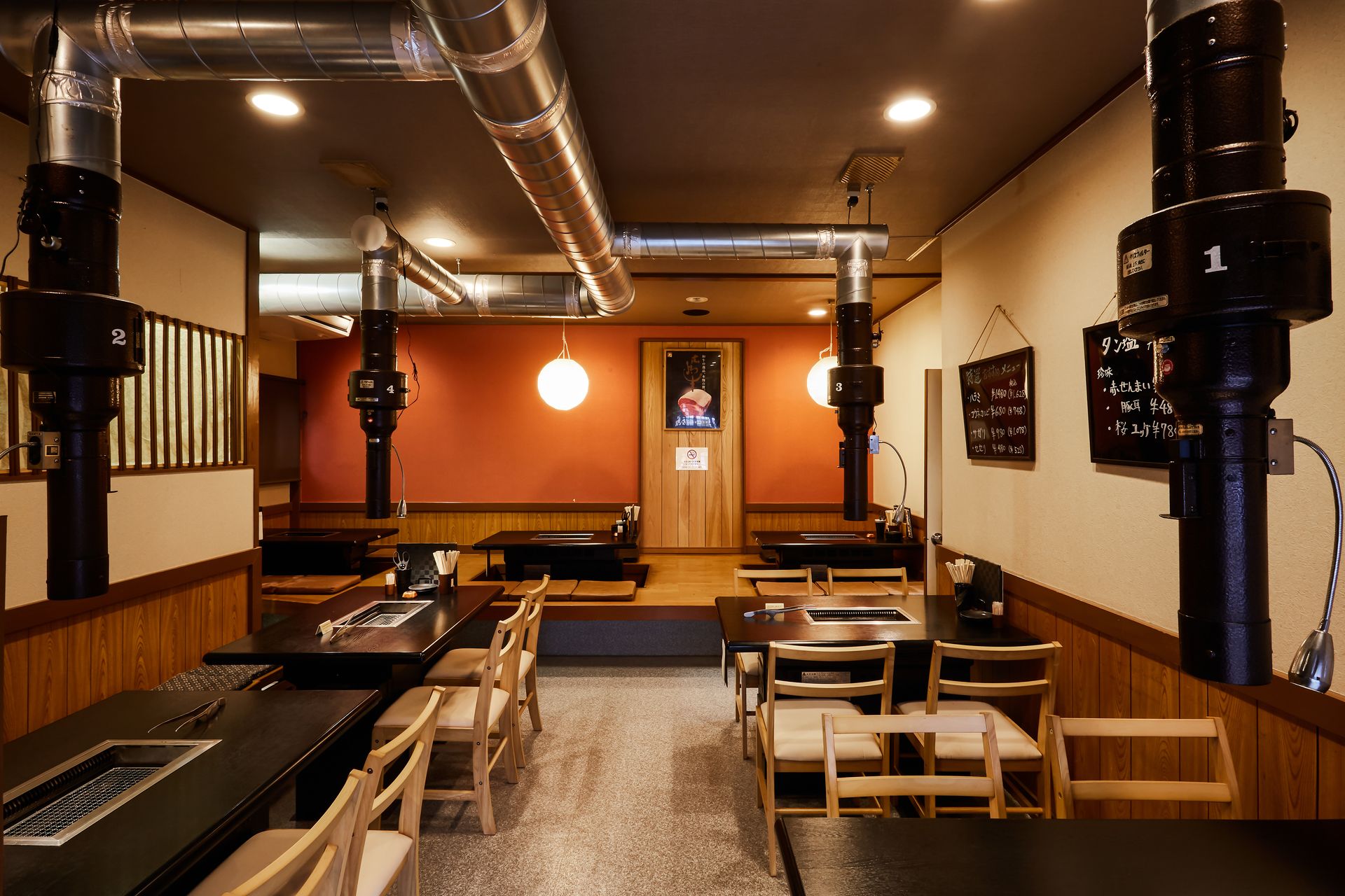 店内全景。掘りごたつの座敷とテーブル席、あたたかな提灯の灯り
